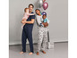 Eine Familie im Pyjama mit Mickey Mouse-Druck und Ballons.