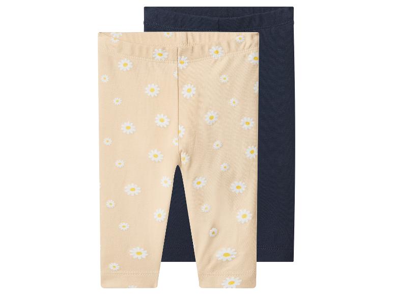 Zwei Baby-Leggings: eine beige mit Gänseblümchen-Print und eine einfarbige dunkelblaue.