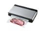 Silbernes Vakuumiergerät mit einem vakuumierten Stück Fleisch.