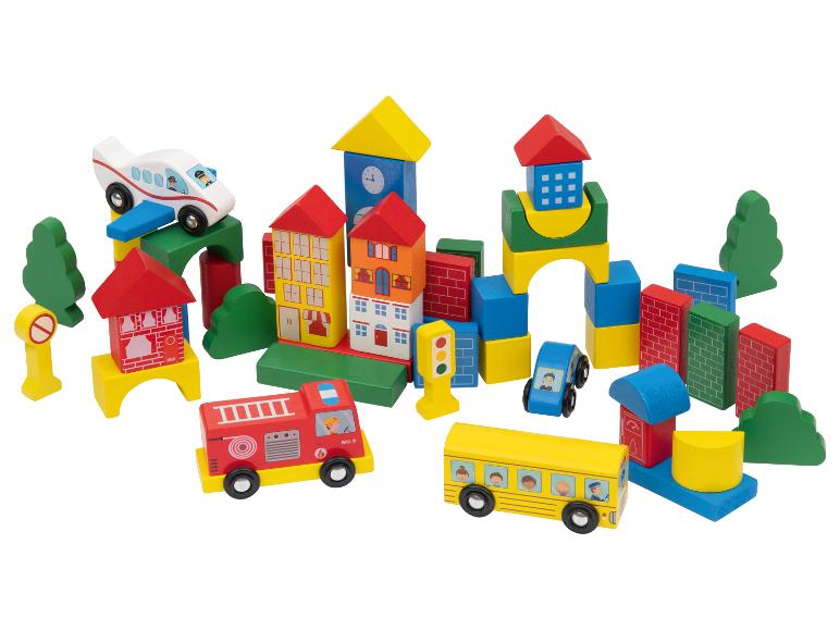 Bunte Holzspielzeugstadt mit Gebäuden, Fahrzeugen und Bäumen.