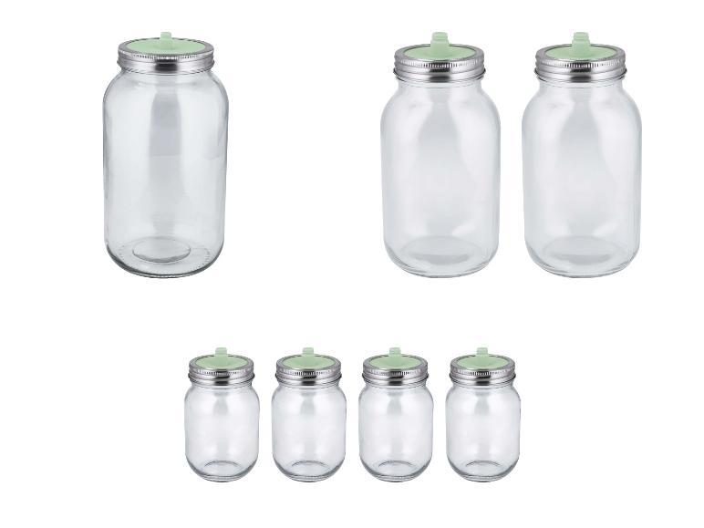 Sets aus klaren Glasgefäßen mit Metalldeckeln und grünen Fermentationsventilen.