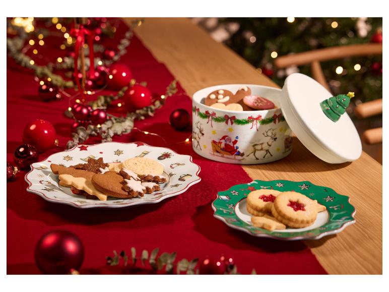 Weihnachtsplätzchen auf festlichen Tellern und in einer Dose mit Weihnachtsmann-Motiv.