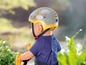 Baby Born Puppe mit Helm und Fahrrad.