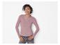 Lächelnde Frau in rosa Langarmshirt und Jeans, trägt Silberschmuck.