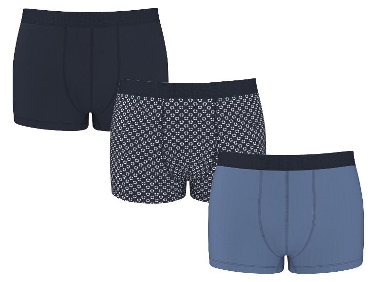 Dreierpack Herren-Baumwollboxershorts: eine marineblaue, eine mit geometrischem Muster und eine hellblaue.