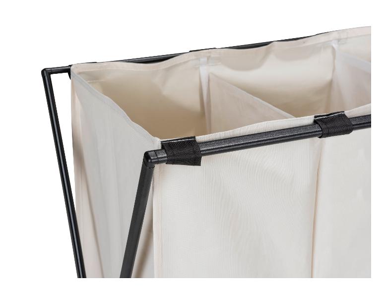 Nahaufnahme eines dreiteiligen Wäschekorbs aus beigefarbenem Stoff mit schwarzem Metallrahmen.