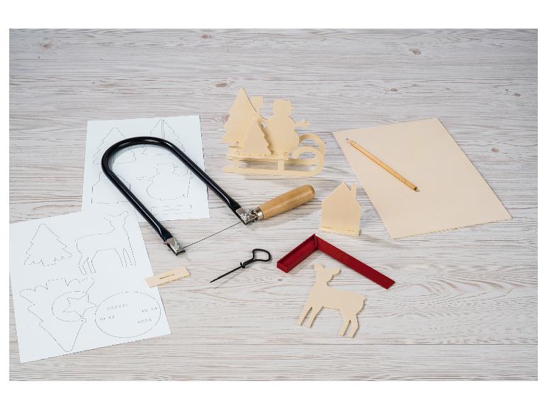 Holzschnitzset mit Säge, Holzfiguren und Schablonen auf einem Holztisch.