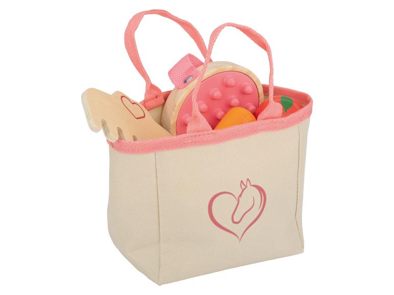 Eine rosa Stofftasche mit Holzspielzeug für Pferde