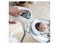 Hand stellt Babyschaukel ein, Baby liegt in der Schaukel