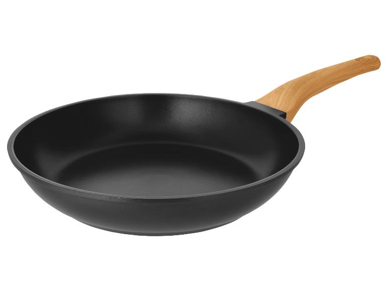 Schwarze Bratpfanne mit Holzgriff auf weißem Hintergrund.
