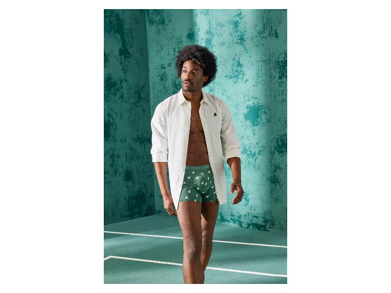 Mann in grünen Boxershorts und offenem Hemd.
