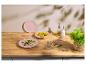 Fleisch- und Suppengerichte auf einem Holztisch mit goldenem Besteck und Kräutern.