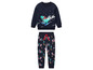 Ein dunkelblauer Pullover mit einem Ski fahrenden Dinosaurier und dazu passende Hose mit Dinosauriern.