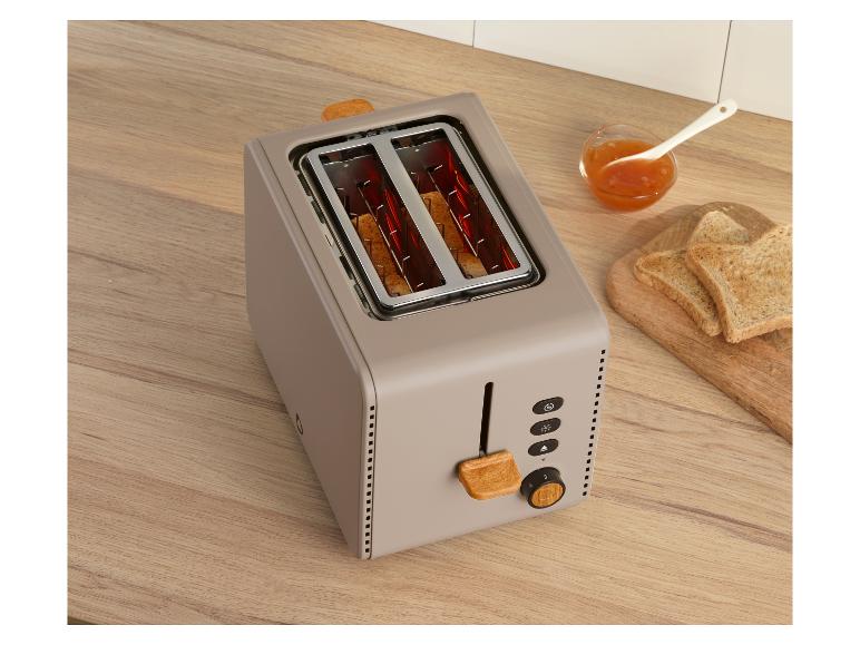 Beiger Toaster mit Holzdetails, Toast und Marmelade auf Holzarbeitsplatte.