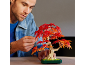 Mann baut einen Spielzeug-Bonsai-Baum mit roten und orangefarbenen Blättern zusammen.