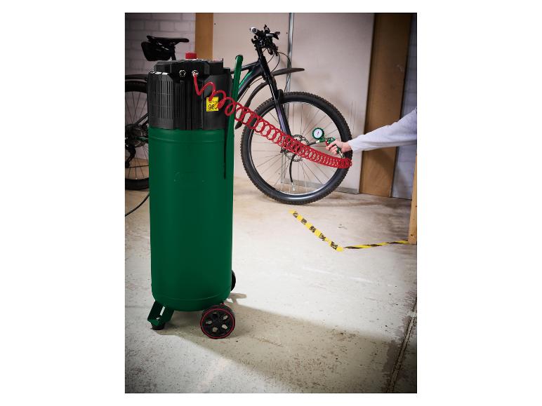 Luftkompressor füllt einen Fahrradreifen, mit einem Fahrrad im Hintergrund.
