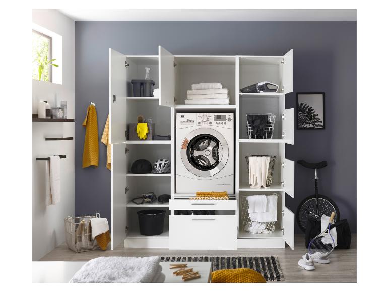 Waschküche mit weißem Aufbewahrungsschrank, Waschmaschine, Handtüchern und Reinigungszubehör.