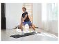 Mann macht Dehnübungen auf einer Fitnessmatte, trägt Sportshirt und Shorts.