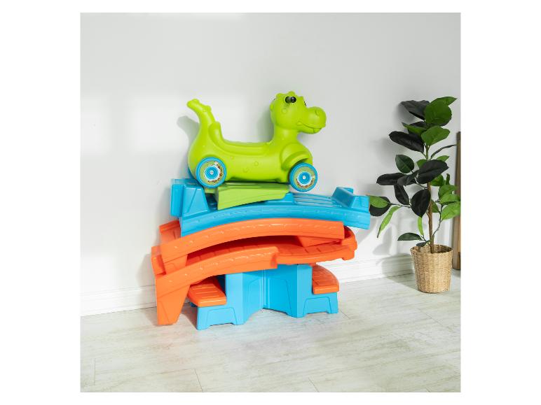 Grüne, blaue und orangefarbene Kunststoffrutsche mit grünem Dinosaurierauto