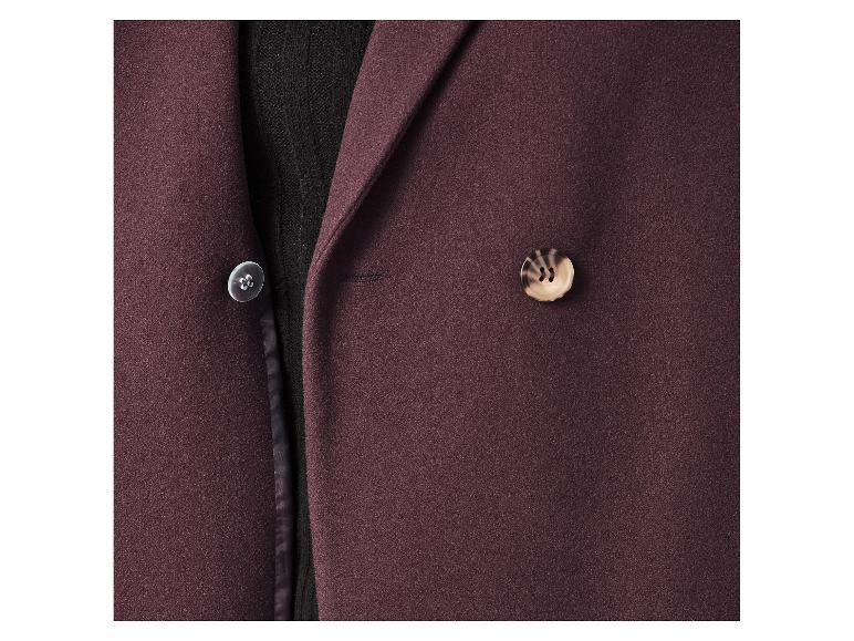 Nahaufnahme eines bordeauxroten Blazers mit Knöpfen und schwarzem Pullover.