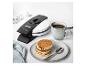 Waffeln mit Schokolade, Kaffee und Waffeleisen auf einem weißen Tisch.