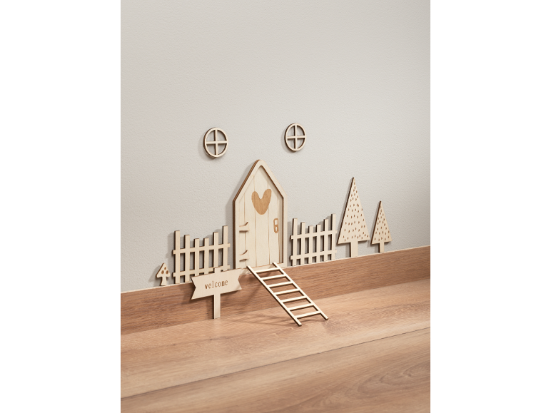 Holzwanddekorationen, darunter ein Feenhaus, Zäune und Bäume.
