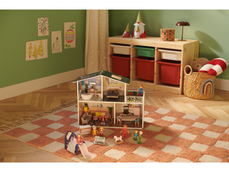 Puppenhaus mit Möbeln und Puppen auf einem karierten Teppich im Kinderzimmer.