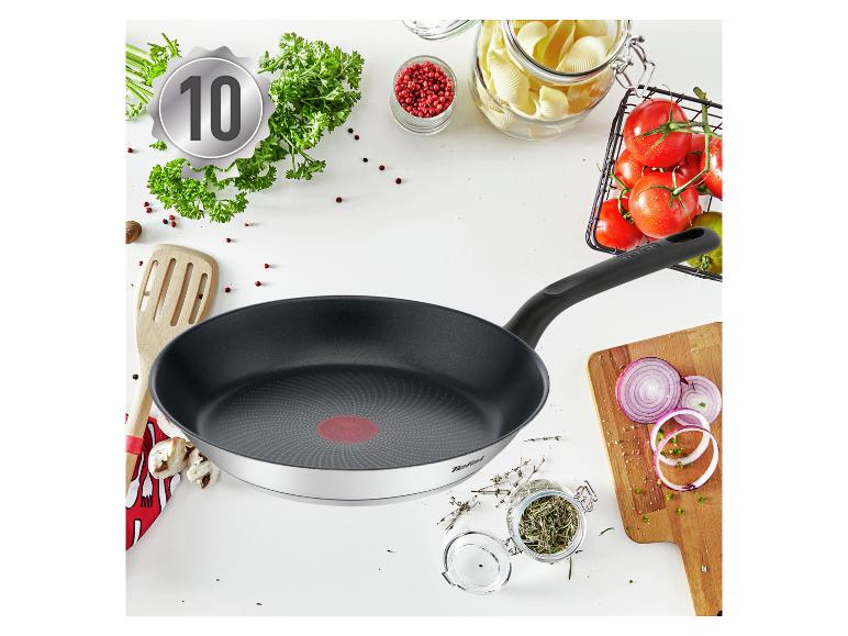 Bratpfanne mit Kochzutaten wie Kräutern, Tomaten und Nudeln, mit einer '10'-Plakette.