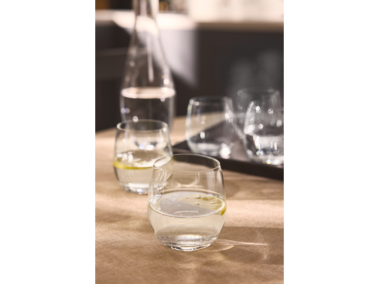 Wasserkaraffe und Gläser mit Zitronenwasser auf einem Tisch.