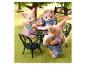 Sylvanian Families Figuren sitzen an einem Tisch im Freien, eine steht daneben.