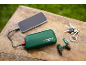 Grüne Powerbank lädt ein Smartphone, mit Schlüsseln und Mini-Bohrmaschinen-Schlüsselanhänger.
