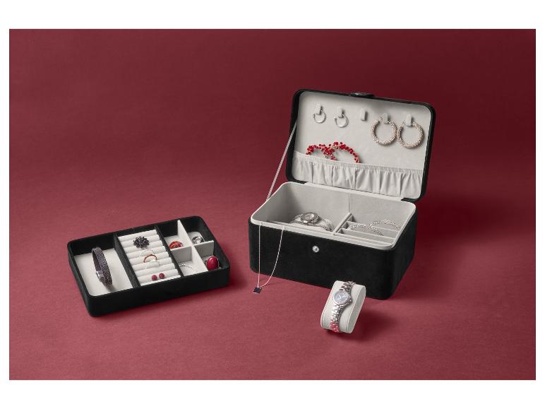 Eine geöffnete Schmuckschatulle mit Ohrringen, Armbändern und einer Uhr.