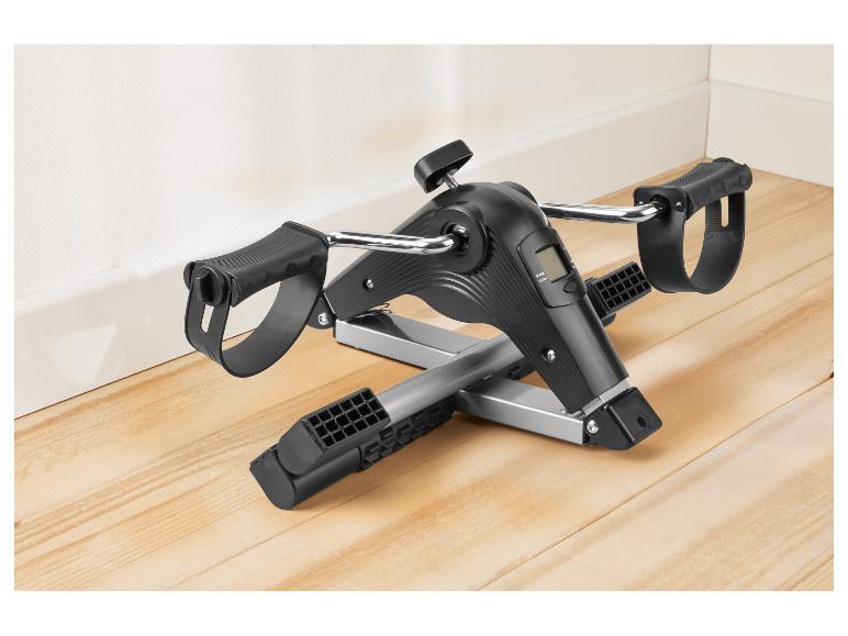 Schwarz-silbernes Mini-Heimtrainer mit Digitalanzeige auf Holzboden.