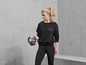Eine Frau in Active Vibes Trainingskleidung hält eine Kettlebell.