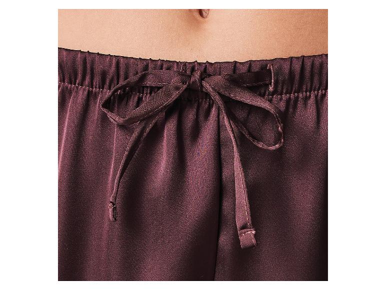 Nahaufnahme eines Bauches und einer dunkelbraunen Pyjamahose mit Kordelzug.