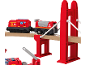 Roter Spielzeug-Feuerwehrzug auf Holzschienen über eine rote Brücke.