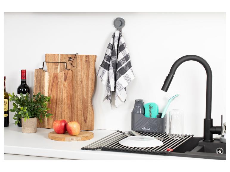 Küchenspüle mit Abtropfgestell, Spülmittel und Schneidebrettern.