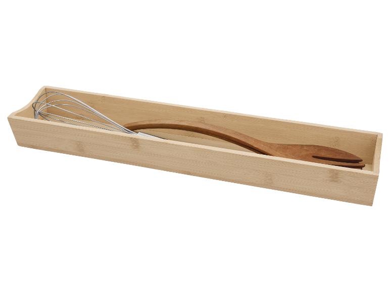 Bambusschale mit Schneebesen und Holzspatel.