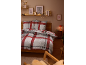 Schlafzimmer mit karierter Bettwäsche, dekorativem Regal mit Lichterkette und gerahmten Bildern.