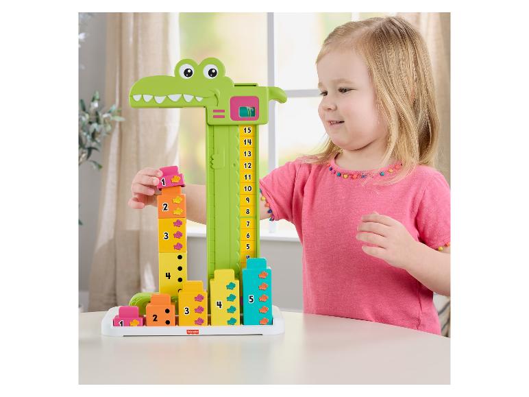 Mädchen spielt mit einem krokodilförmigen Stapelspiel mit nummerierten Blöcken.