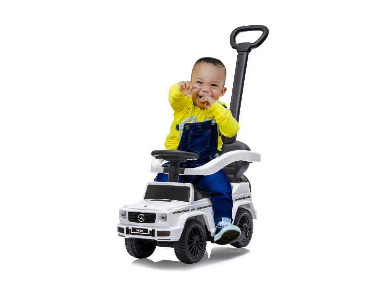 Ein kleines Kind spielt mit einem Mercedes-Benz G-Klasse Spielzeugauto.