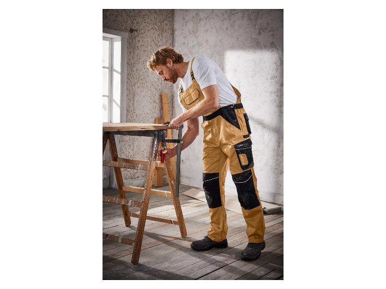 Ein Mann in Arbeitskleidung verwendet eine Zwinge, um Holz zu fixieren.