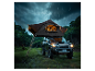 SUV mit Dachzelt und Leiter, im Wald bei starkem Regen geparkt.