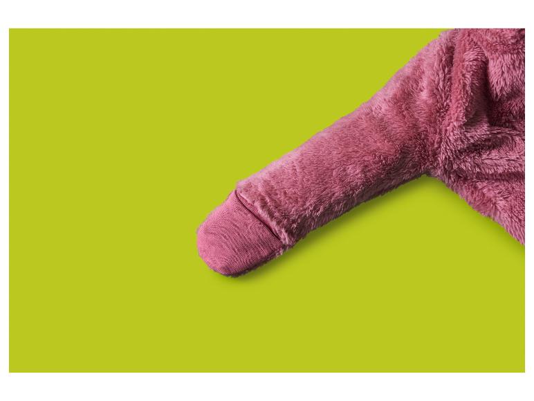 Rosa flauschiger Ärmel eines Bademantels oder Pyjamas auf limettengrünem Hintergrund.