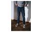 Mann in grauem Sweatshirt und dunkelblauer Jeans mit Turnschuhen.