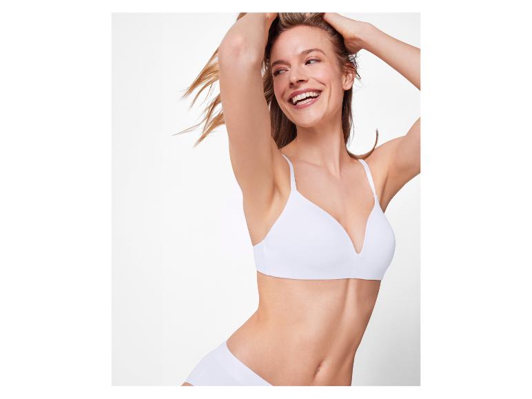 Lächelnde Frau in weißem BH und Slip.