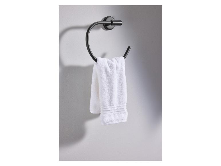 Ein weißes Handtuch hängt an einem schwarzen, an der Wand montierten Handtuchhalter.