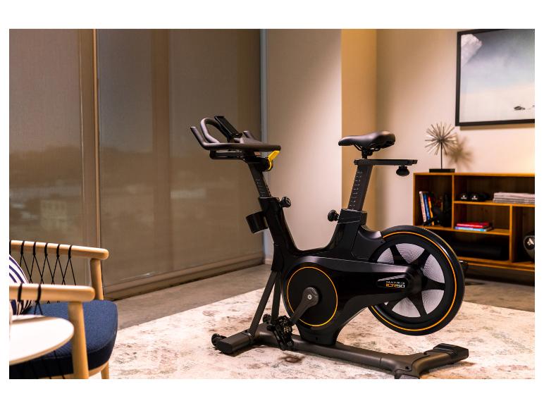 Schwarzes Heimtrainer in einem Raum mit Sessel und Regal.