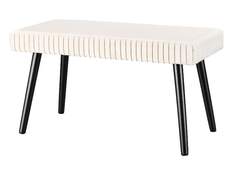 Eine weiße Samtbank mit schwarzen Beinen.