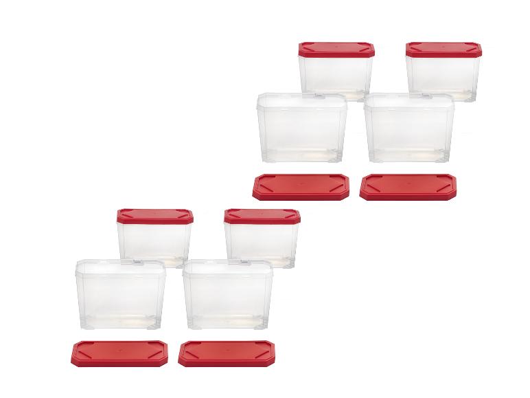Transparente Plastik-Lebensmittelbehälter mit roten Deckeln, diagonal angeordnet.